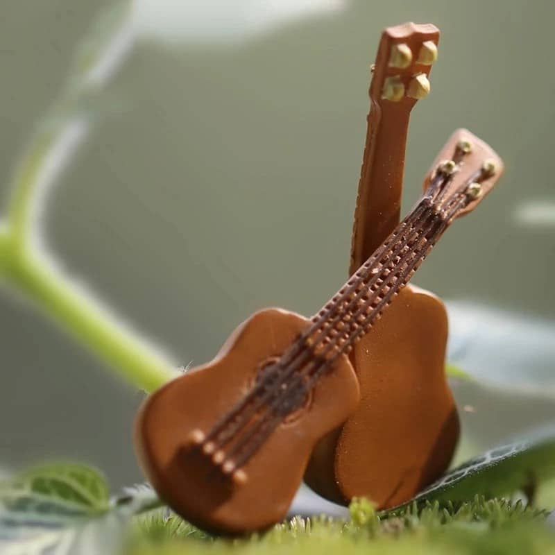 Detaillierte Ansicht einer realistischen Miniatur-Akustikgitarre aus Kunststoff