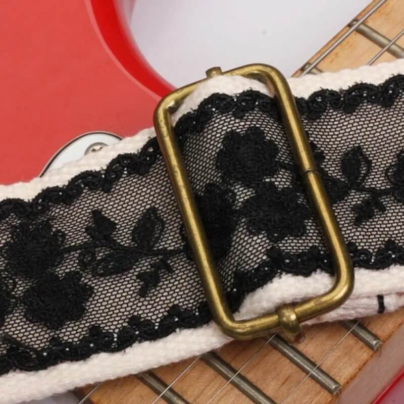 Details der Gitarrengurtschlaufe mit schwarzer floraler Spitze