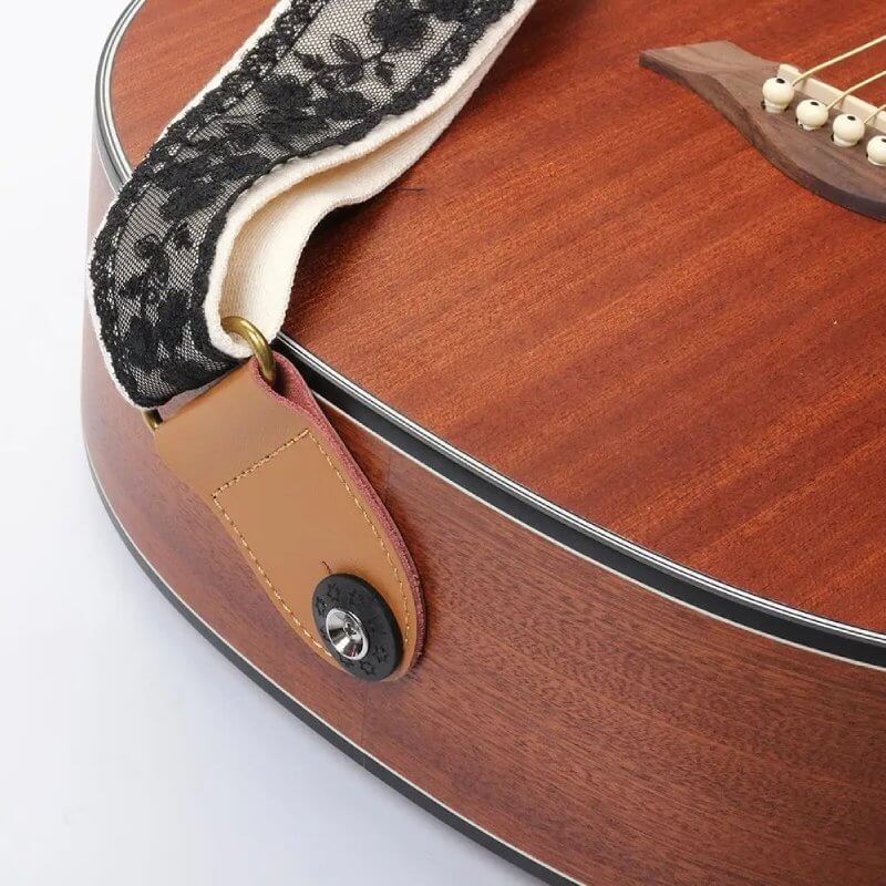 Ansicht der Befestigungen des schwarzen Gitarrengurts mit floralem Spitzenmuster