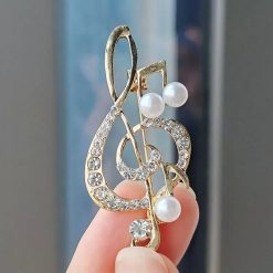 Brosche in Form eines Violinschlüssels, verziert mit Strass und Perlen