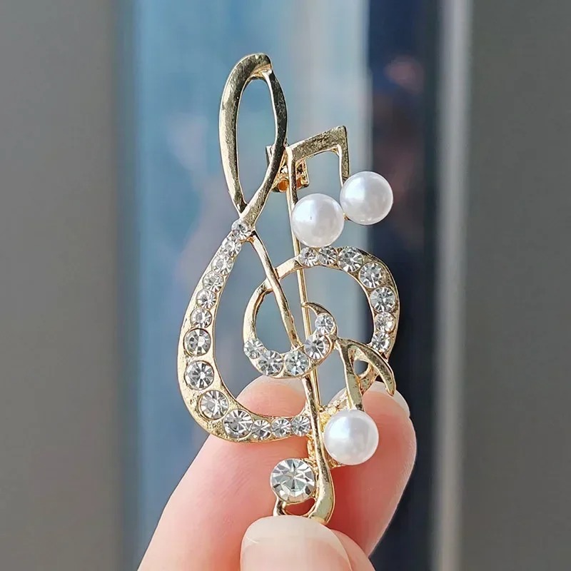 Brosche in Form eines Violinschlüssels, verziert mit Strass und Perlen