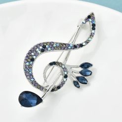 Brosche in Form eines Violinschlüssels mit blauen Strasssteinen
