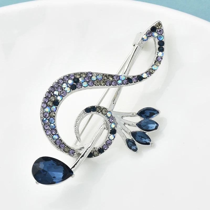 Brosche in Form eines Violinschlüssels mit blauen Strasssteinen