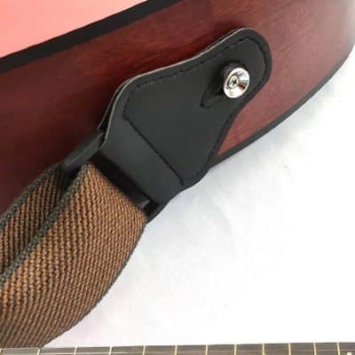Detail der klassischen Gitarrengurtbefestigung in Kaffeebraun