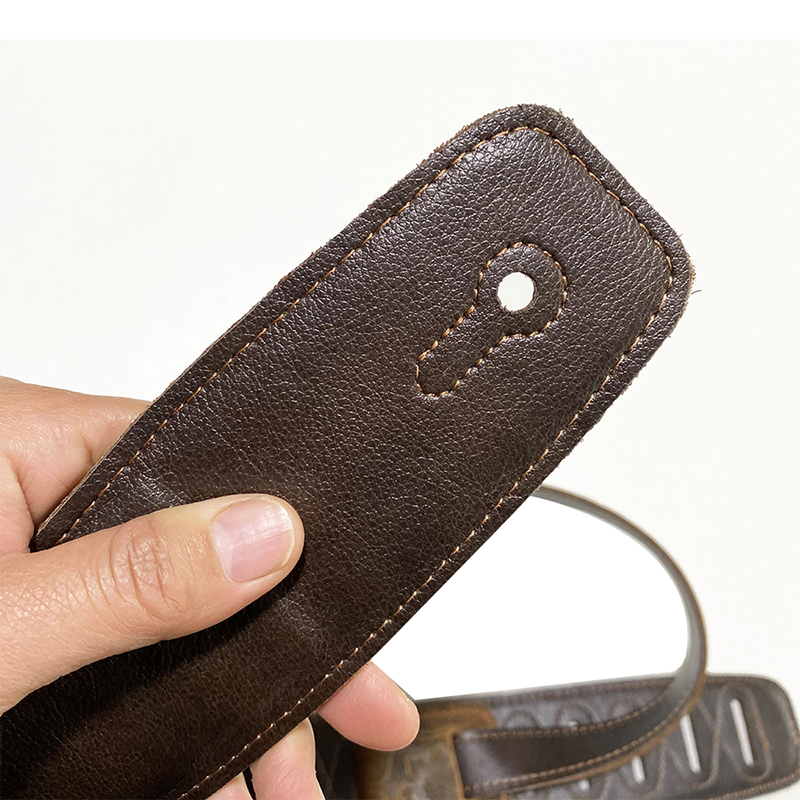 vue intérieure de sangle en cuir marron gaufré pour guitare folk